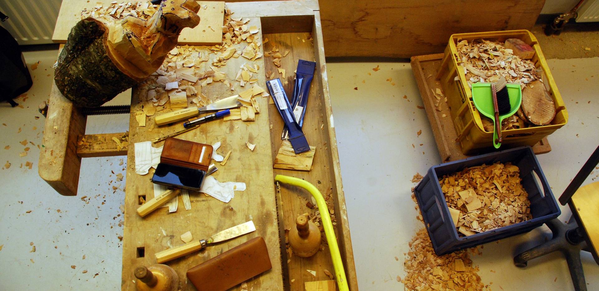 Auf dem Bild sind diverse Holzwerkzeuge abgebildet. Es wird an einer Tierskulptur gearbeitet. Auf dem Bild sind diverse Holzwerkzeuge abgebildet. Es wird an einer Tierskulptur gearbeitet.