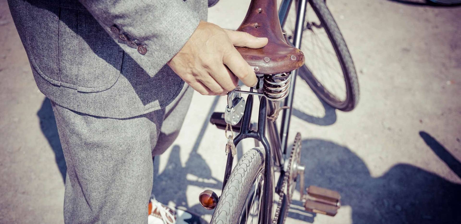 Ein in Tweed gekleideter Herr bei seinem stilvollen alten Fahrrad.