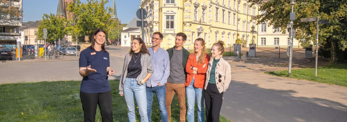 Gruppe bei einer Stadtführung vor dem Oldenburger Schloss