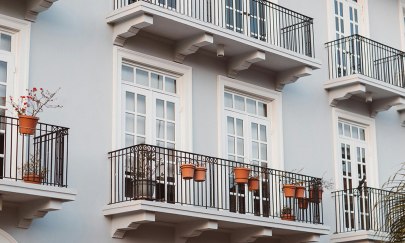 Große weiße Fenster mit einem schwarzen Balkon.
