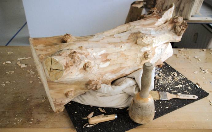 Man sieht ein Stück Holz das gerade mit Hilfe von Werkzeugen bearbeitet wird. Man sieht ein Stück Holz das gerade mit Hilfe von Werkzeugen bearbeitet wird.
