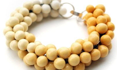 Man erkennt ein Armband, welches aus vielen kleinen Prozellan Perlen besteht. Man erkennt ein Armband, welches aus vielen kleinen Prozellan Perlen besteht.