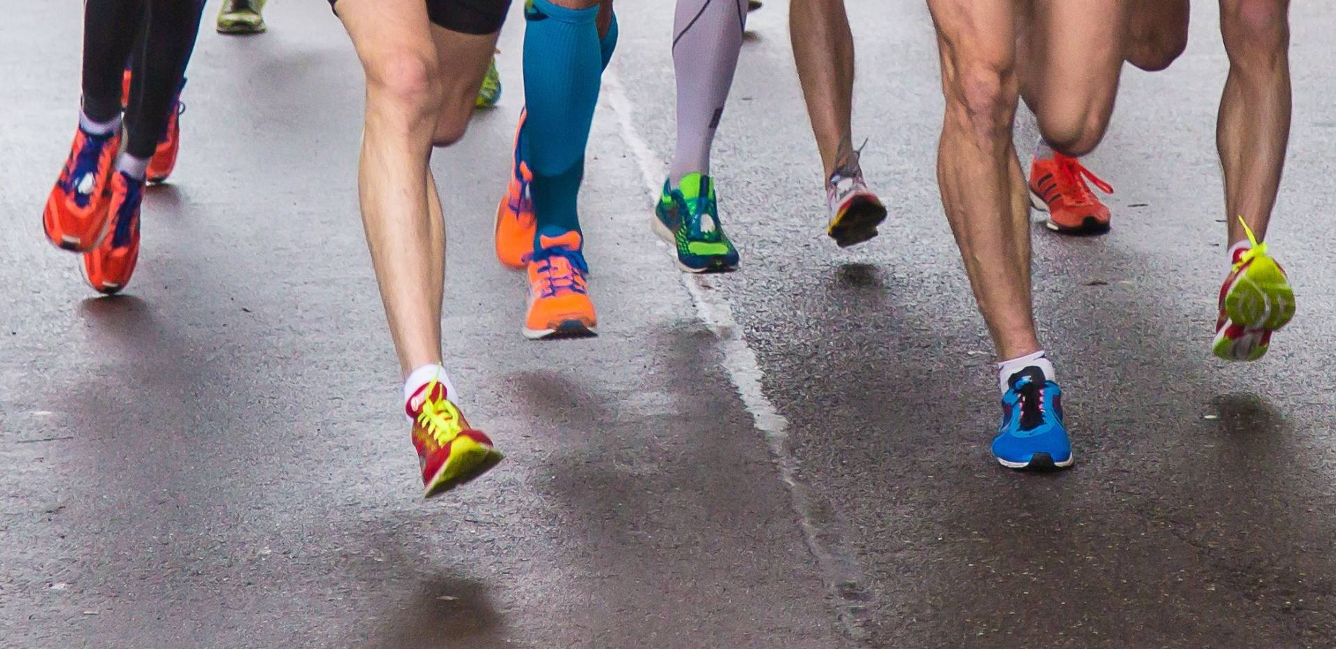 Füße von Marathonläufern auf der Straße.