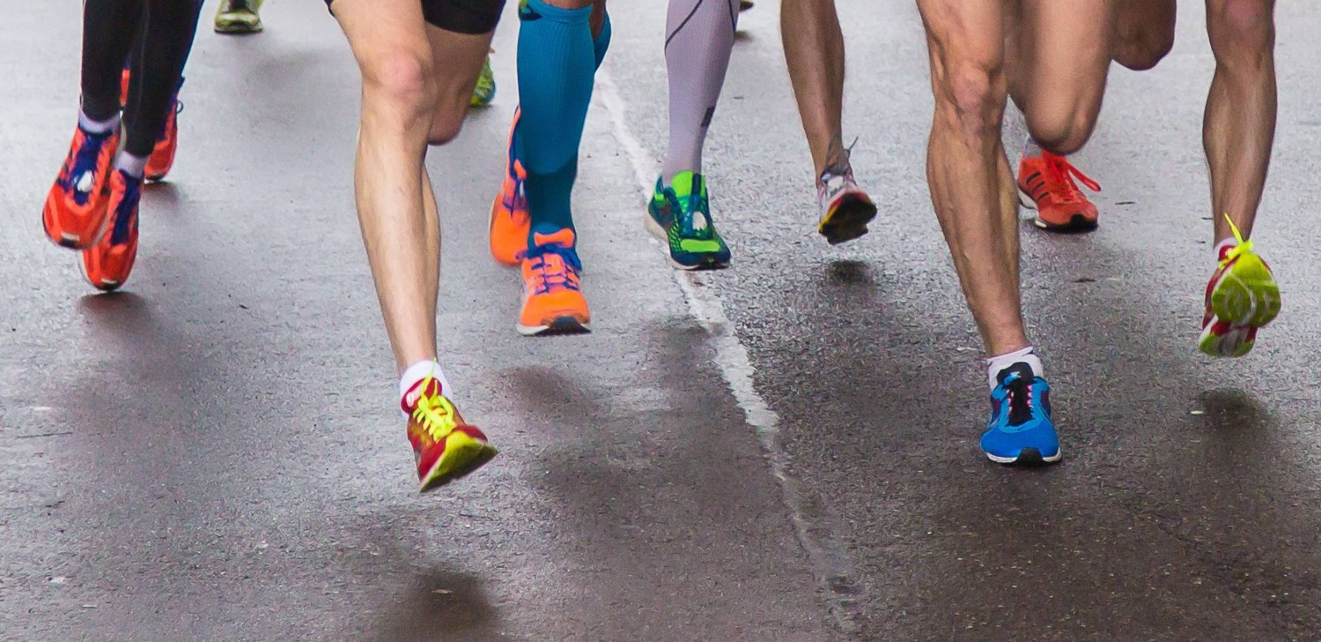 Füße von Marathonläufern auf der Straße.