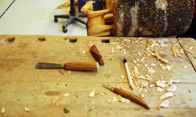 Auf dem Foto befinden sich eine Holzskulptur und einige Werkzeuge. Auf dem Foto befinden sich eine Holzskulptur und einige Werkzeuge.