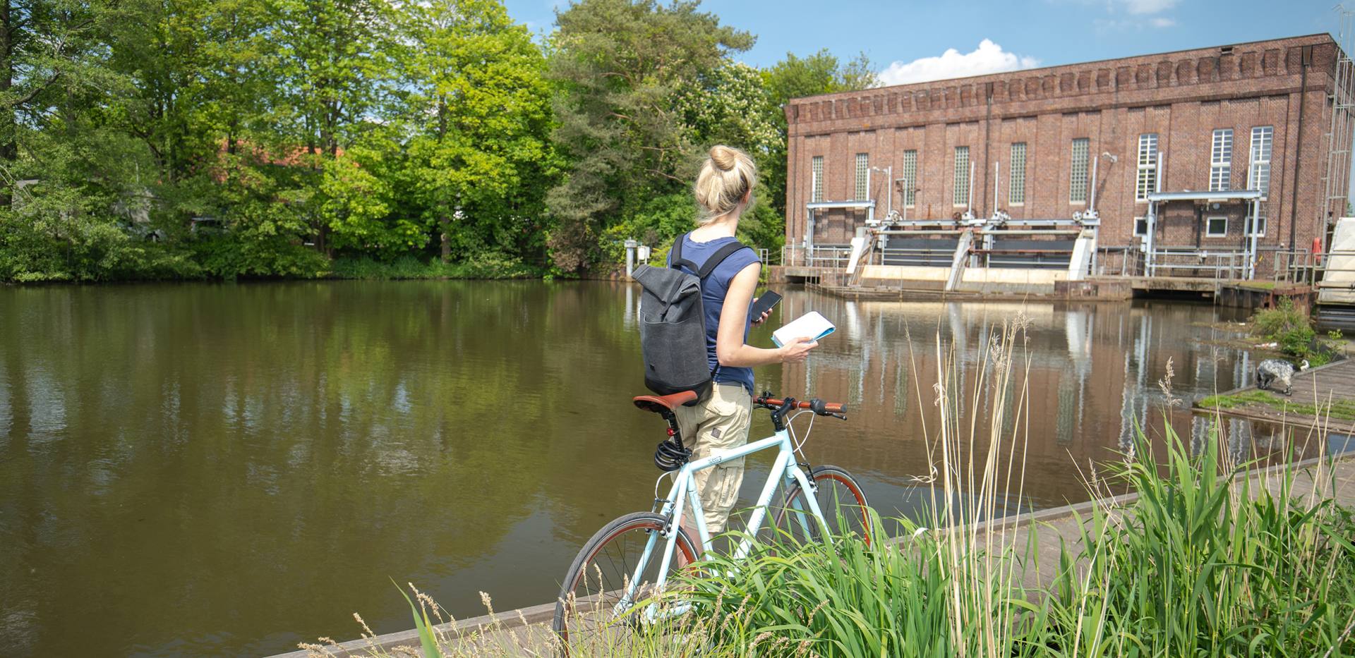 Die Oldenburger Geotour besteht aus vierzehn Caches, die an für den Klimaschutz interessanten Orten innerhalb des Stadtgebietes liegen. Hier ist eine Radfahrerin am GeoCache Wasserwerk zu sehen.