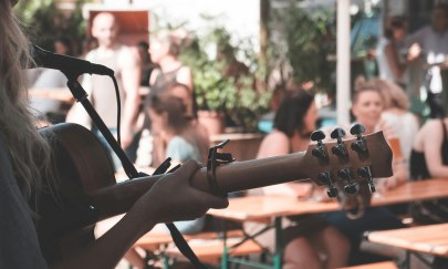 Person die auf der Gitarre spielt und dabei singt. Person die auf der Gitarre spielt und dabei singt.