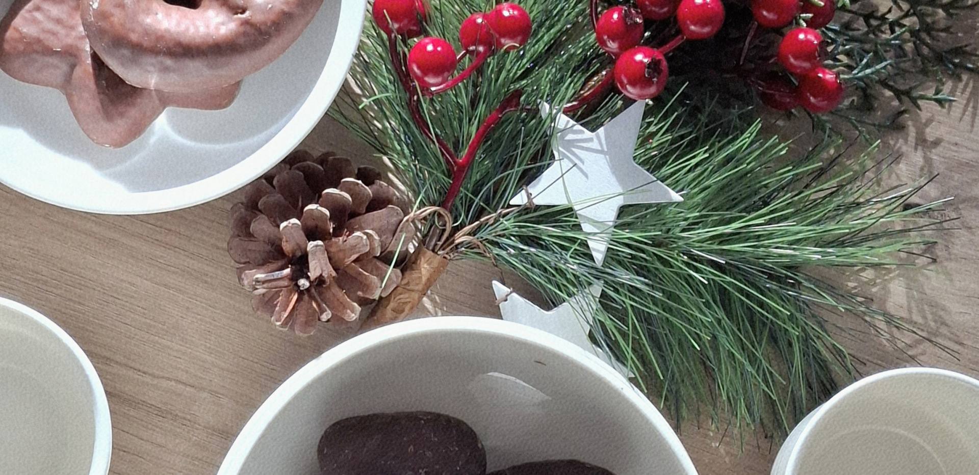 Auf einem Tisch liegen weihnachtliche Dekorationen mit Lebkuchen und einem Tannenzweig. Auf einem Tisch liegen weihnachtliche Dekorationen mit Lebkuchen und einem Tannenzweig.