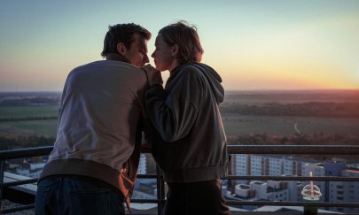 Auf dem Bild sind 2 Personen zu erkennen, die sich nahestehen. Links steht eine männlich gelesene Person und rechts steht eine weiblich gelesene Person. Im Hintergrund ist ein Sonnenauf- oder untergang zu erknnen. Auf dem Bild sind 2 Personen zu erkennen, die sich nahestehen. Links steht eine männlich gelesene Person und rechts steht eine weiblich gelesene Person. Im Hintergrund ist ein Sonnenauf- oder untergang zu erknnen.