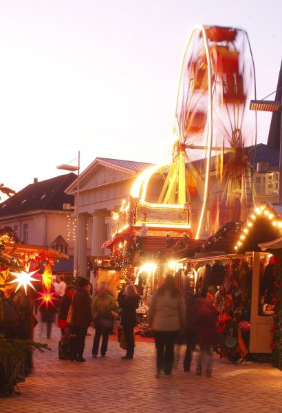 Das Kinderriesenrad auf dem Oldenburger Weihnachtsmarkt mit der Schlosswache im Hintergrund.