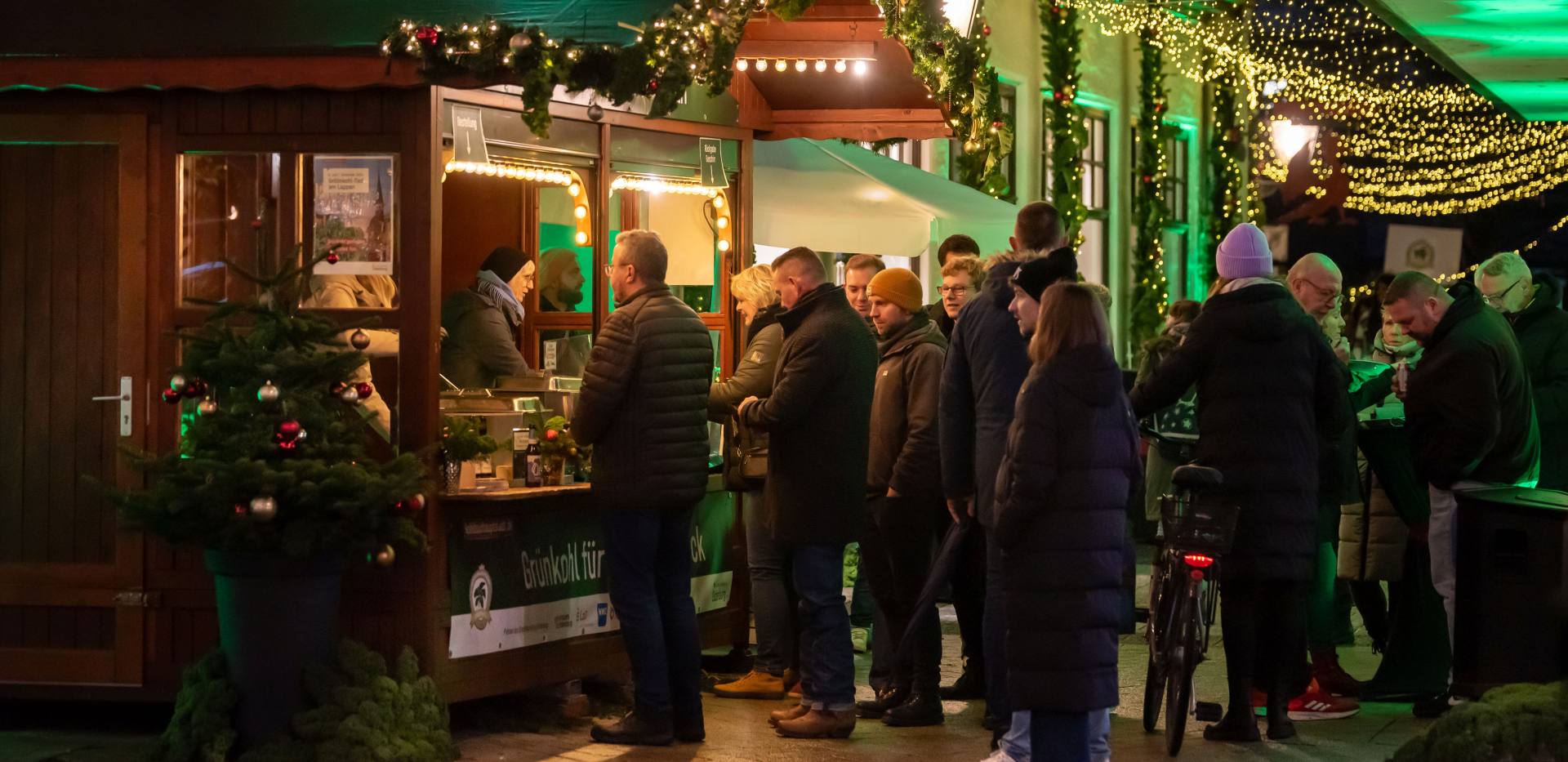 Eine Menschenschlange vor dem Aktionsstand der OTM "Gröönkohl-Tied" und der festlich geschmückte Lappangang.