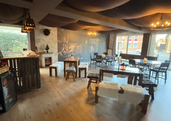 Unsere gemütliche Fantasytaverne mit Holztischen, (künstlichen) Fellen, stimmungsvollem Wandbild und Kamin. Sie dient zum einen als Empfangsraum für unseren Escape Room und zum anderen als Veranstaltungsraum - egal, ob für eure privaten oder Firmenevents oder für von uns ausgerichtete Fantasyevents!