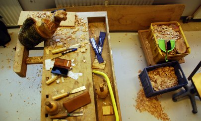 Auf dem Bild sind diverse Holzwerkzeuge abgebildet. Es wird an einer Tierskulptur gearbeitet. Auf dem Bild sind diverse Holzwerkzeuge abgebildet. Es wird an einer Tierskulptur gearbeitet.