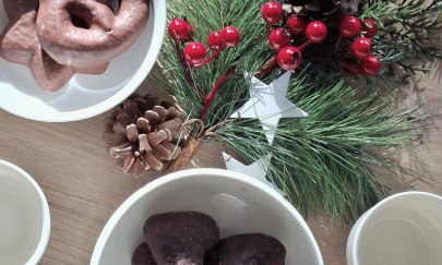 Auf einem Tisch liegen weihnachtliche Dekorationen mit Lebkuchen und einem Tannenzweig. Auf einem Tisch liegen weihnachtliche Dekorationen mit Lebkuchen und einem Tannenzweig.
