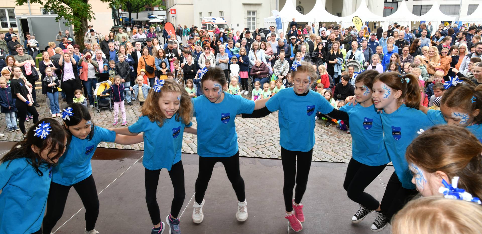 Kinder führen auf einer Bühne auf dem Schlossplatz vor Publikum etwas vor. Foto: Tobias Frick Kinder führen auf einer Bühne auf dem Schlossplatz vor Publikum etwas vor. Foto: Tobias Frick