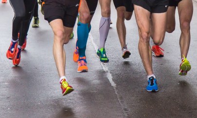 Füße von Marathonläufern auf der Straße.