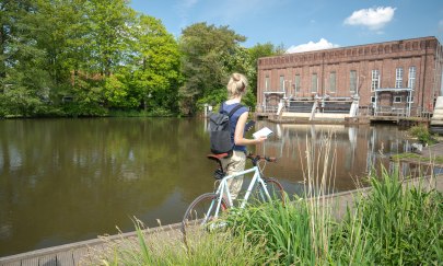 Die Oldenburger Geotour besteht aus vierzehn Caches, die an für den Klimaschutz interessanten Orten innerhalb des Stadtgebietes liegen. Hier ist eine Radfahrerin am GeoCache Wasserwerk zu sehen.