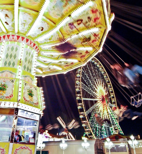 Nachtaufnahme mit beleuchtetem Kettenkarussell und Riesenrad auf dem Oldenburger Kramermarkt.