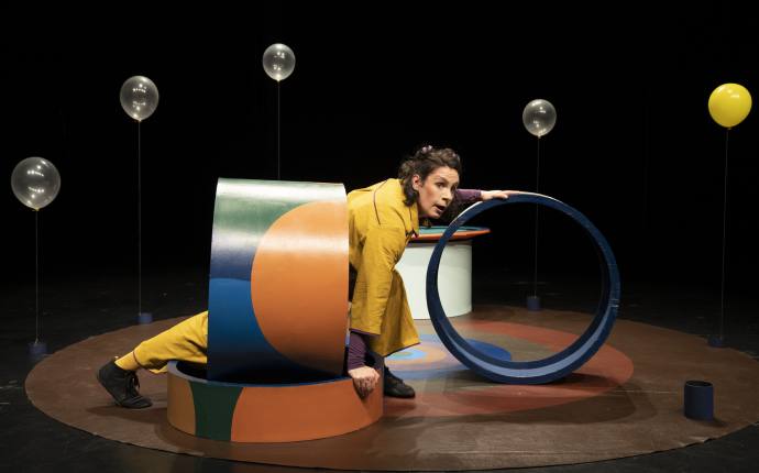 Schauspielerin schlüpft durch bunte Röhre