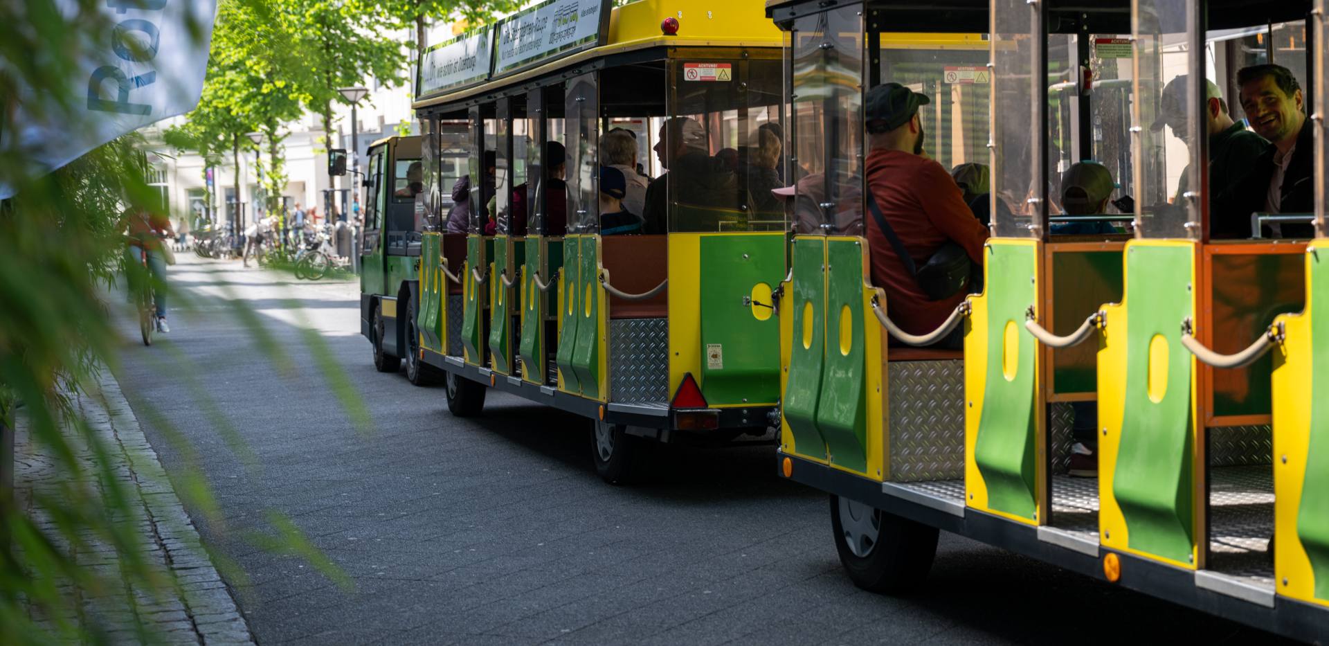Die elektrisch betriebene Bimmelbahn (Stadtgärten-Raupe) auf einer Fahrt durch die Fußgängerzone am Eröffnungstag der Stadtgärten 2025.