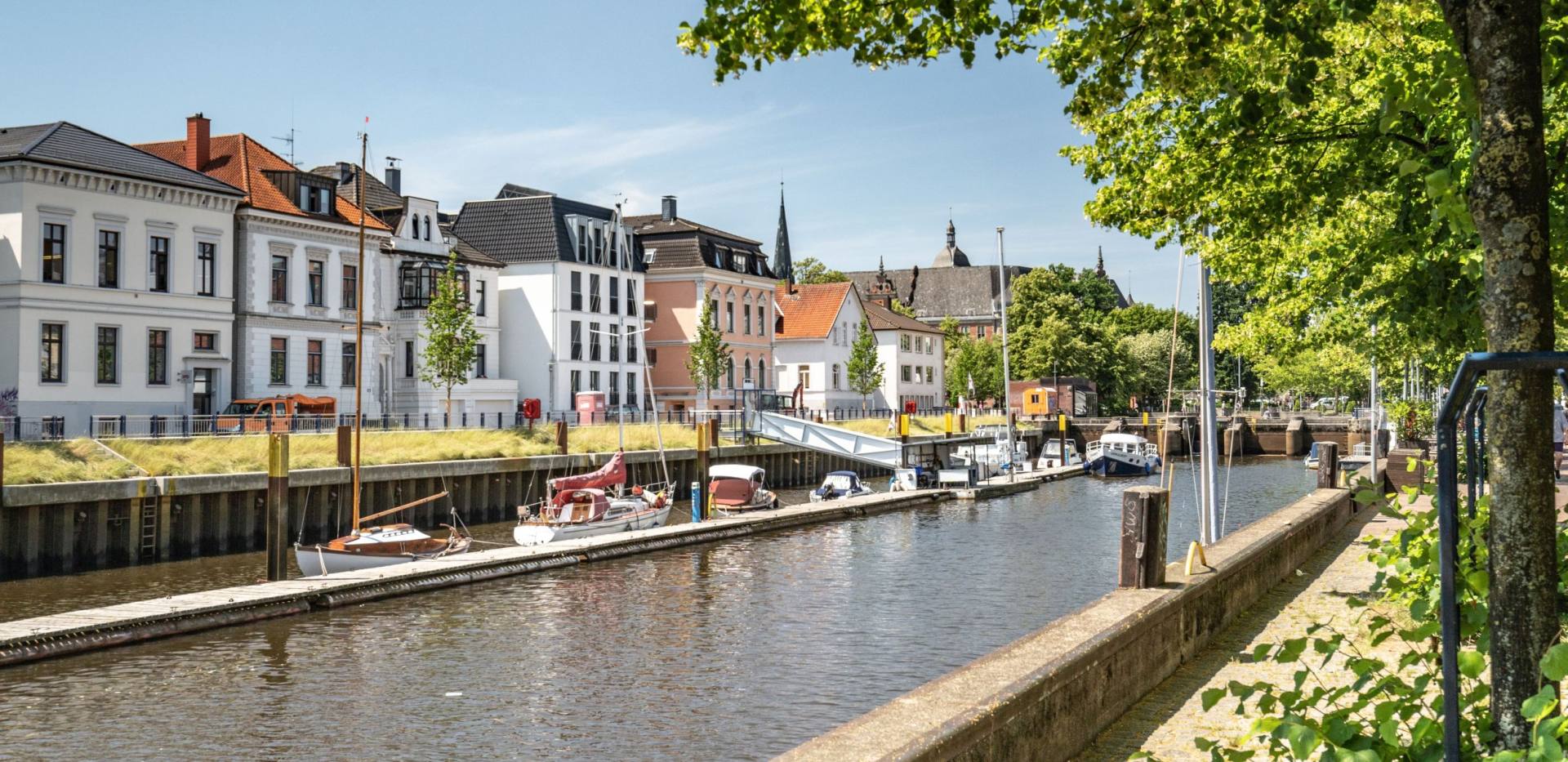 Oldenburger Hafenbecken mit gegenüberliegenden Wohnhäusern und der Hafenpromenade rechts mit Blickrichtung Innenstadt. 