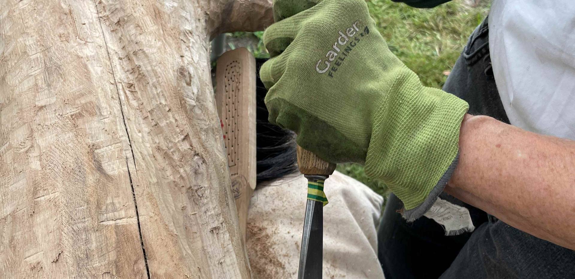 Auf dem Foto wird an einer Holzskulptur gearbeitet.
