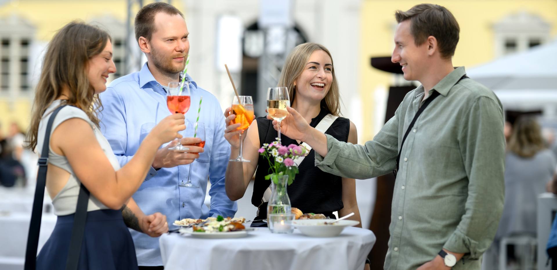 Eine Freundesgruppe beim Ansto&szlig;en bei Kochen am Schloss Oldenburg