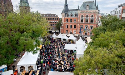 Auf dem Oldenburger Rathausmarkt sind zu hallo Grünkohl viele Stände und lange Sitzreihen zum Essen aufgebaut.