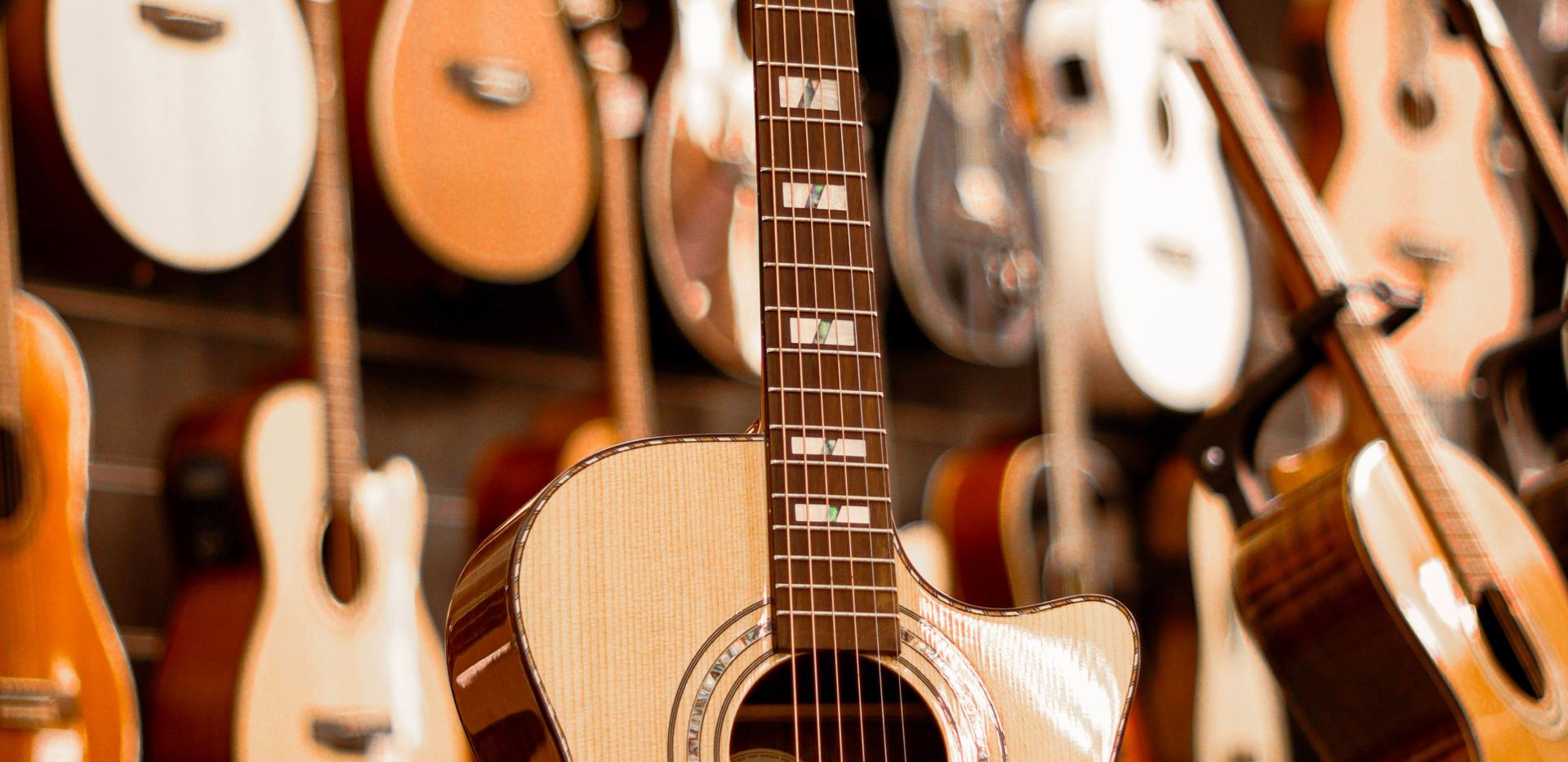 Nahaufnahme einer schönen Akustikgitarre in einem Musikgeschäft, die Handwerkskunst hervorhebt. Foto: Marayah Stumbo/Pexels Nahaufnahme einer schönen Akustikgitarre in einem Musikgeschäft, die Handwerkskunst hervorhebt. Foto: Marayah Stumbo/Pexels
