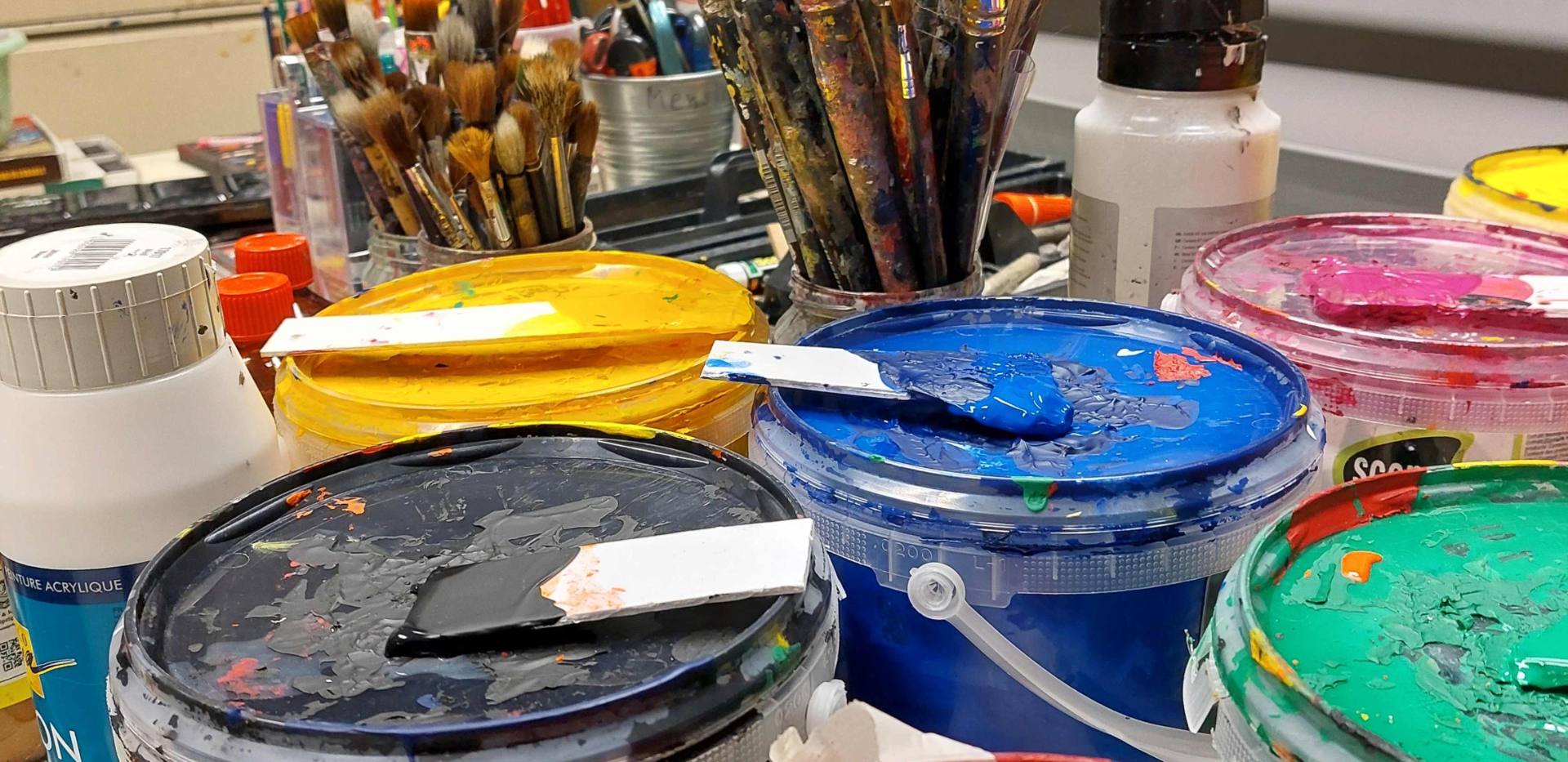 Auf dem Bild sind verschiedene Farbeimer, Pinsel und weitere Malutensilien zu sehen. Auf dem Bild sind verschiedene Farbeimer, Pinsel und weitere Malutensilien zu sehen.