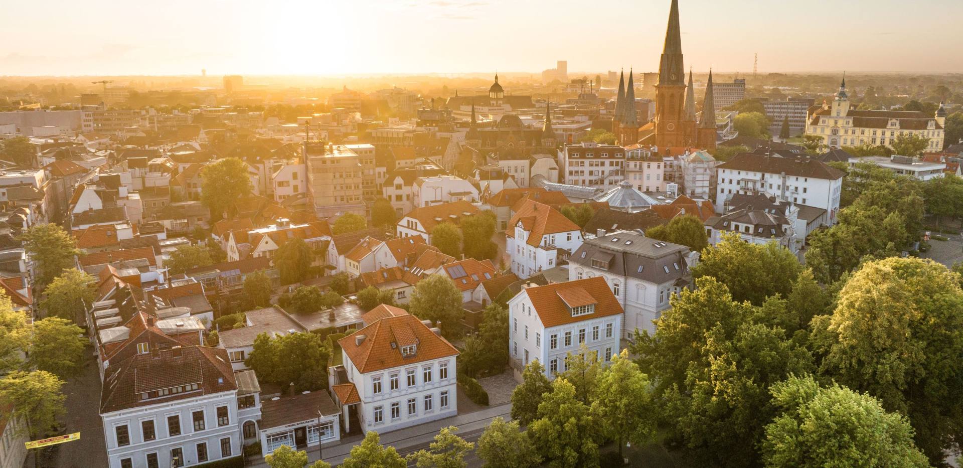 Luftblick auf die Innenstadt mit Schloss und St. Lamberti-Kirche im Hintergrund. 