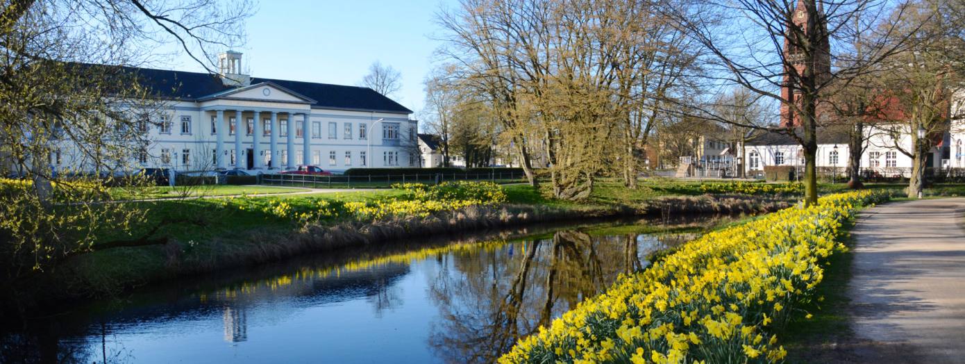 PFL Oldenburg mit Wallanlagen und Narzissen im Vordergrund