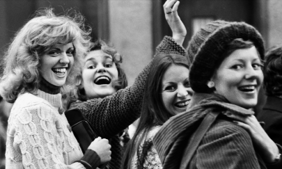 Schwarz weiß Bild mit 4 Frauen die in die Kamera lächeln.