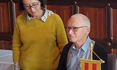Gerry Hahlo sitzt an einem Tisch und trägt seinen Namen in das Goldene Buch der Stadt Oldenburg ein. Neben ihm steht eine Dame und spricht zu ihm. Gerry Hahlo sitzt an einem Tisch und trägt seinen Namen in das Goldene Buch der Stadt Oldenburg ein. Neben ihm steht eine Dame und spricht zu ihm.