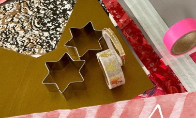 Man erkennt verschiedene Papiere, sternf&ouml;rmige Ausstecher und Klebeband.