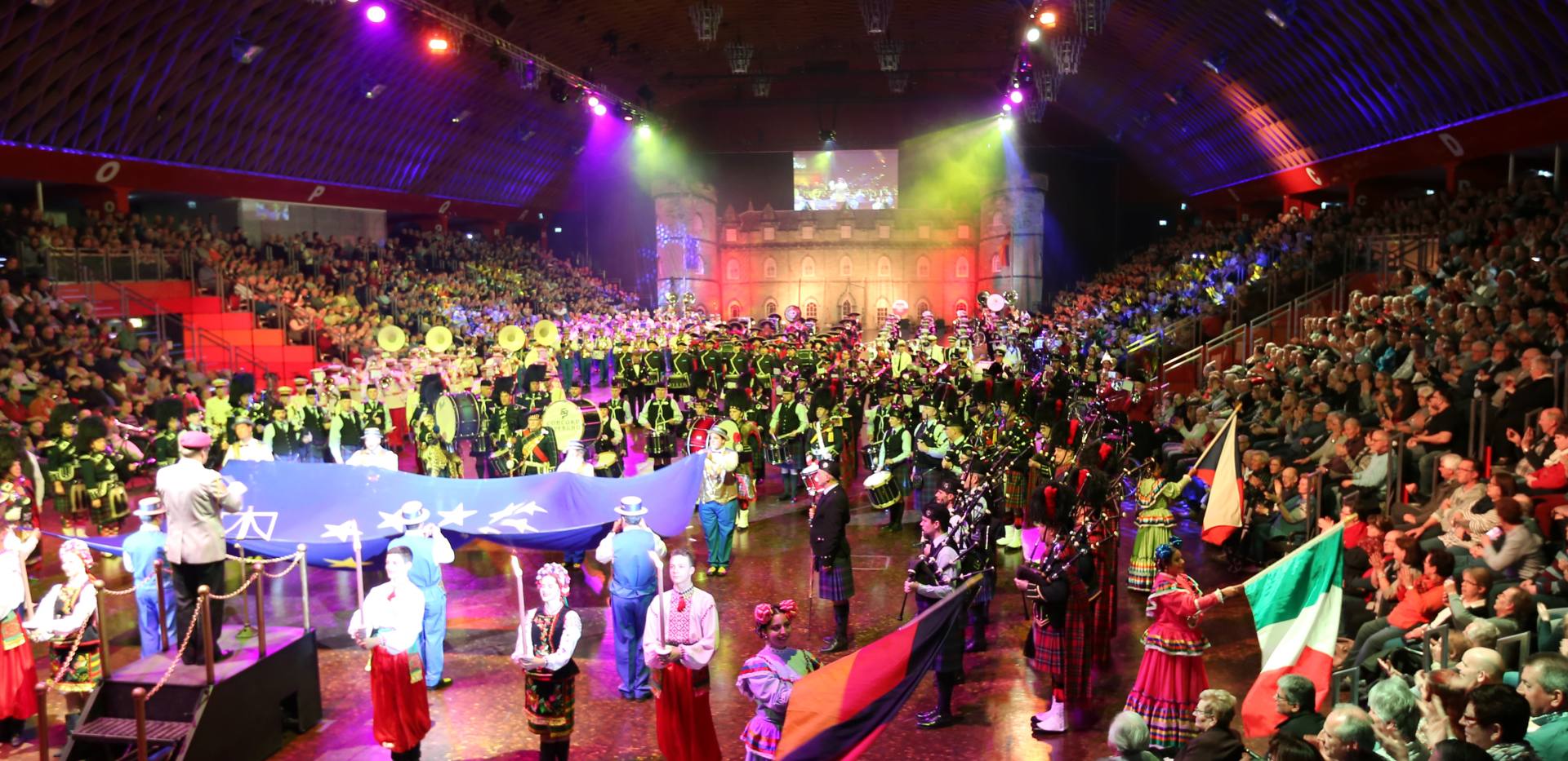 Das große Finale der MUSIKPARADE mit über 400 Künstlern aus verschiedenen Nationen in einer farbenprächtigen Choreografie. Dudelsackspieler, Marschkapellen und traditionelle Trachtengruppen präsentieren sich gemeinsam unter festlicher Lichtinszenierung in einer voll besetzten Arena. Im Zentrum weht eine große Europafahne – ein musikalisches und visuelles Symbol der Völkerverständigung.