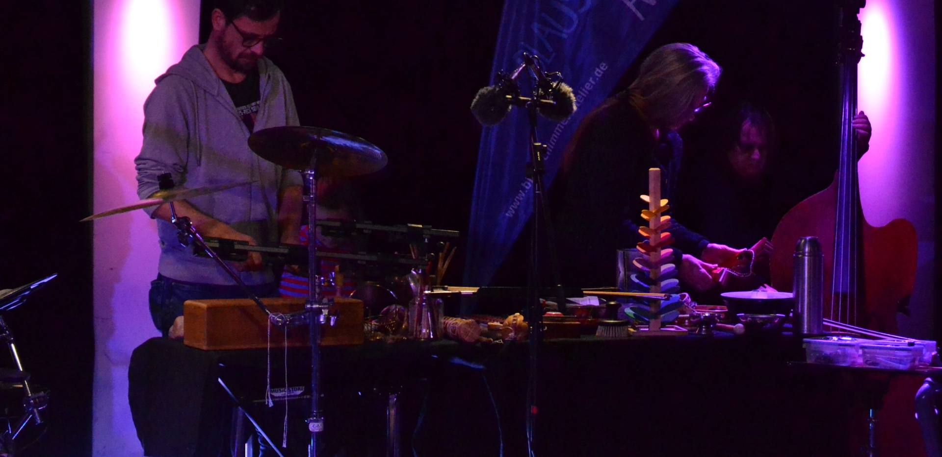 Drei Musiker*innen an diversen Instrumenten bei der Offenen Bühne.