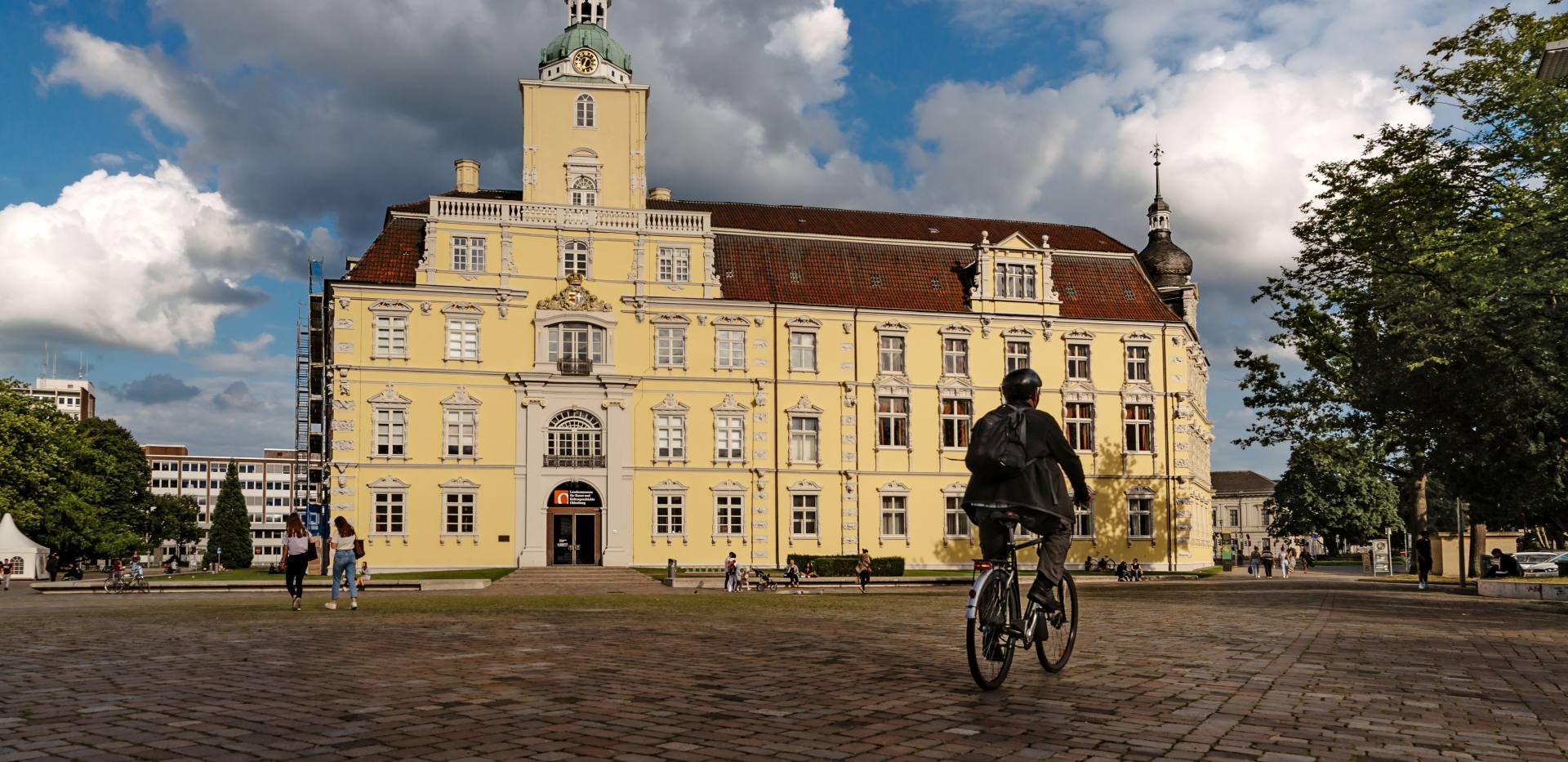 Blick auf das Oldenburger Schloss mit Schlossplatz und Radfahrer.