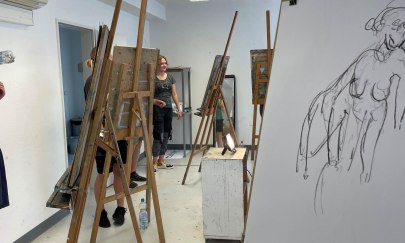 Auf dem Foto erkennt man mehrere Staffeleien und Personen. An der vordersten Staffelei wird an einer Aktzeichnung gearbeitet. Auf dem Foto erkennt man mehrere Staffeleien und Personen. An der vordersten Staffelei wird an einer Aktzeichnung gearbeitet.