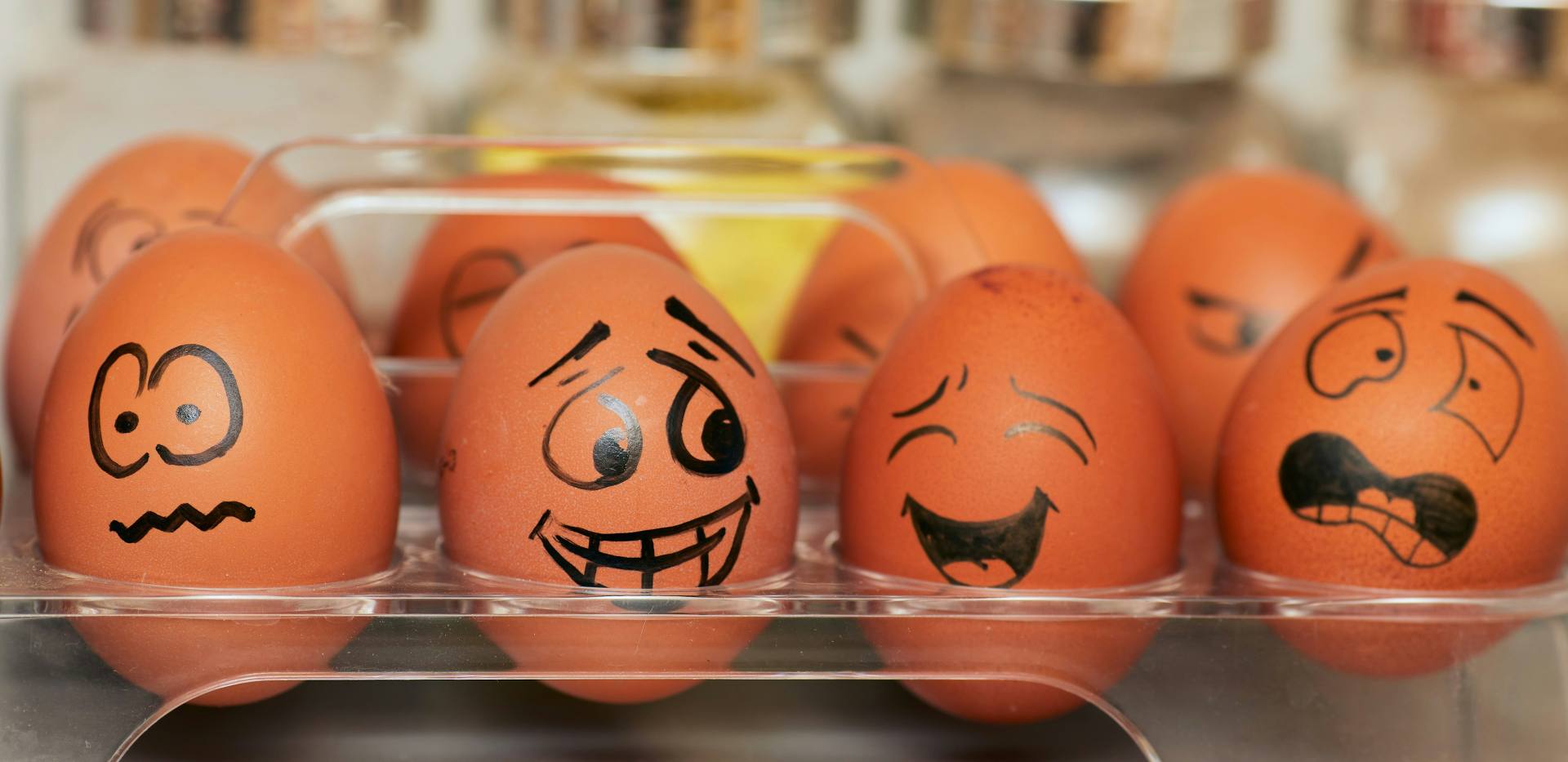 Eier im Kühschrak mit verschiedenen aufgemalten Emotionen Eier im Kühschrak mit verschiedenen aufgemalten Emotionen