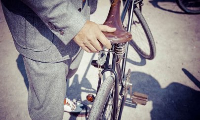 Ein in Tweed gekleideter Herr bei seinem stilvollen alten Fahrrad.