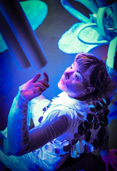 Schauspielerin schaut interessiert eine Poolnudel an