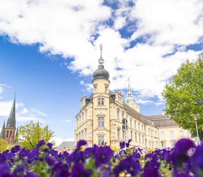 Sehenswürdigkeit Oldenburger Schloss mit Blumen im Vordergrund