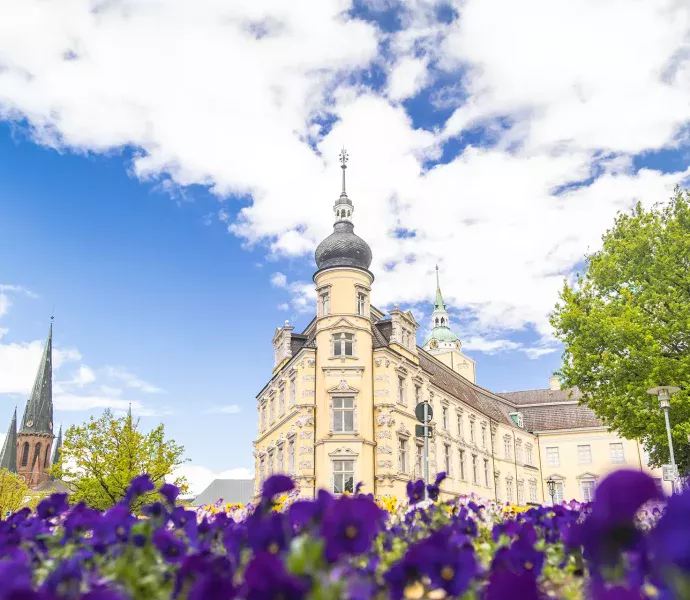 Sehenswürdigkeit Oldenburger Schloss mit Blumen im Vordergrund