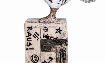 Man erkennt eine Figur von einem Finken, welcher mit verschiedenen Sprüchen verziert wurde und zusätzlich auf einen ähnlich gestalteten Sockel steht. Man erkennt eine Figur von einem Finken, welcher mit verschiedenen Sprüchen verziert wurde und zusätzlich auf einen ähnlich gestalteten Sockel steht.