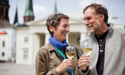 Beim Weinfest Oldenburg genießt ein Pärchen ein Glas Weißwein auf dem Schlossplatz.