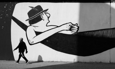 Street Art Motiv eines Mannes in einer Hängematte mit Fußgänger in schwarz weiß