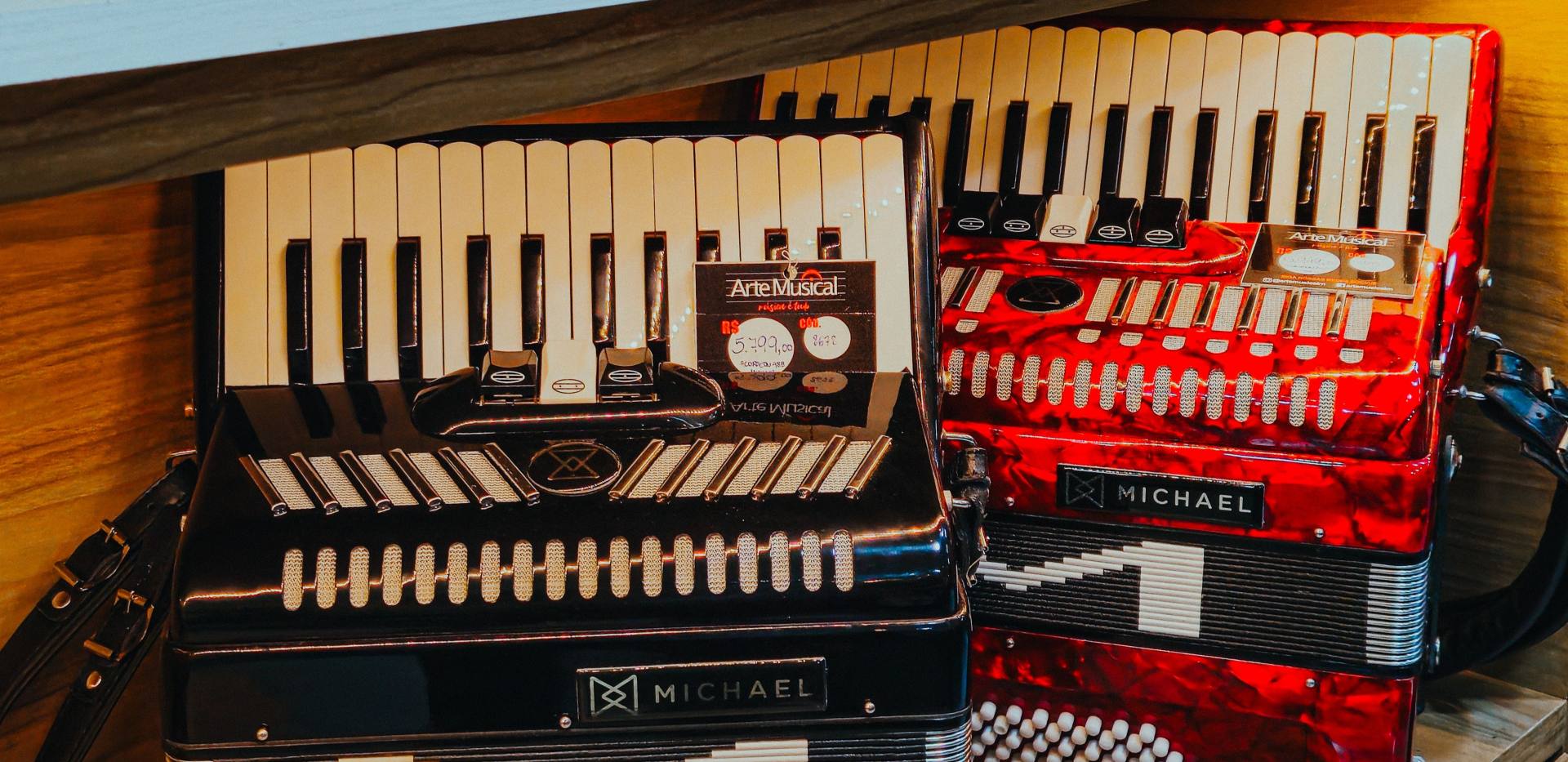 Leuchtend rote und schwarze Akkordeons auf einem Holzregal mit Musikzubeh&ouml;r. Foto: Ivett M/Pexels