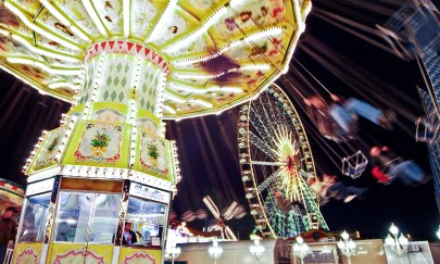 Nachtaufnahme mit beleuchtetem Kettenkarussell und Riesenrad auf dem Oldenburger Kramermarkt.