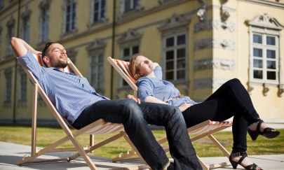 Ein Pärchen im Liegestuhl auf dem Oldenburger Schlossplatz vor dem Schloss.